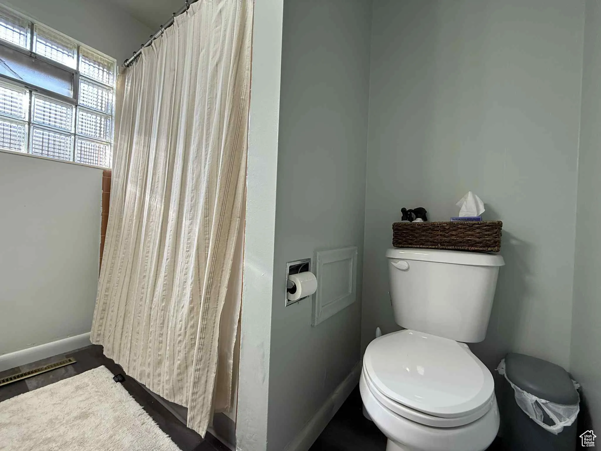 Bathroom featuring toilet and a shower with curtain