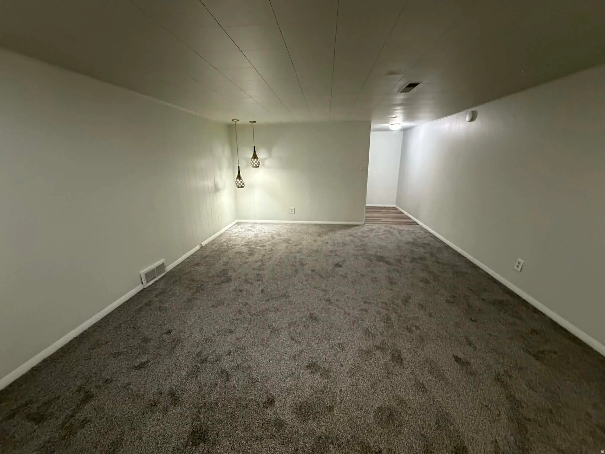 Spare room with dark colored carpet and baseboards