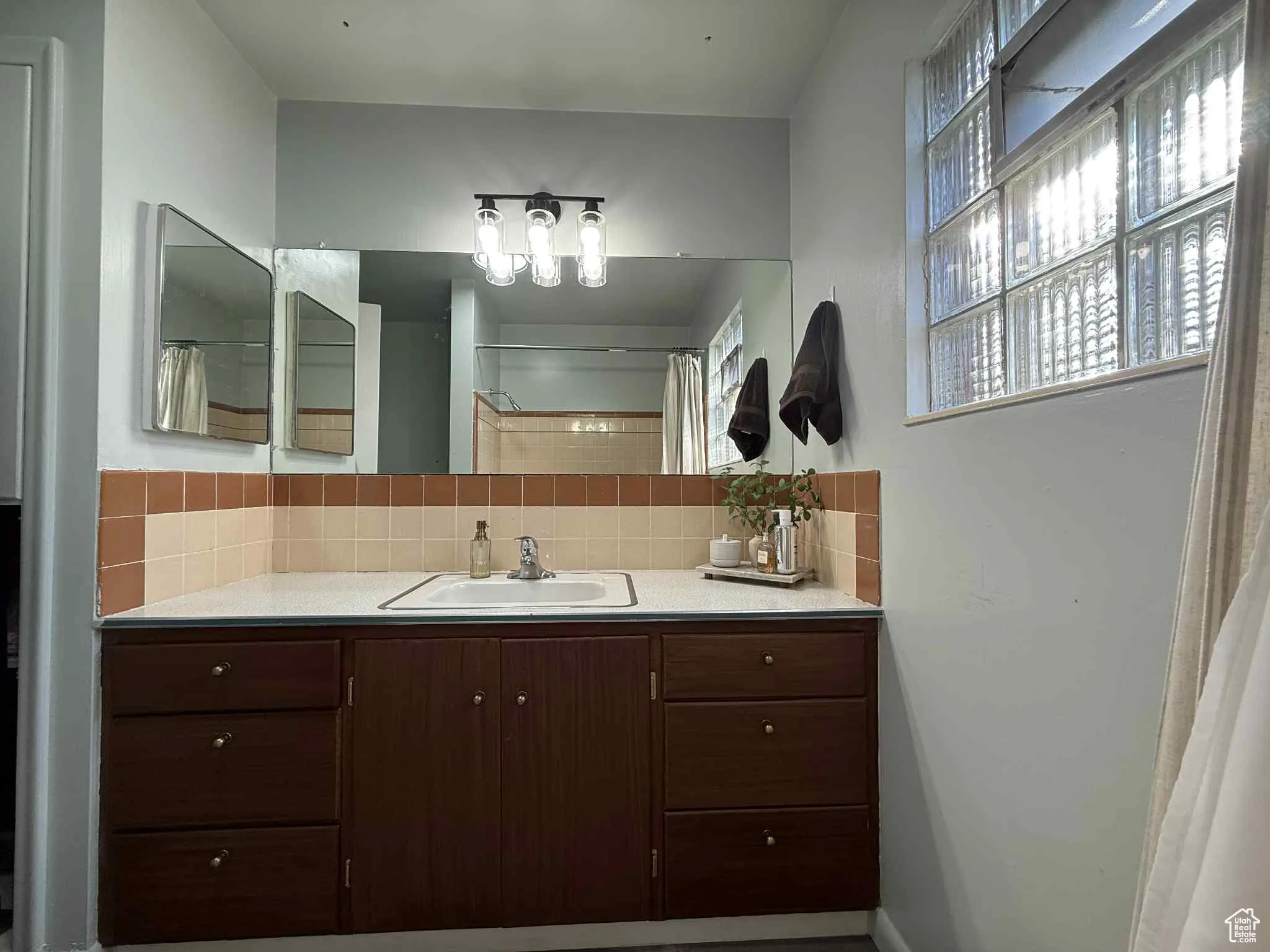 Full bath featuring backsplash, vanity, and a shower with curtain