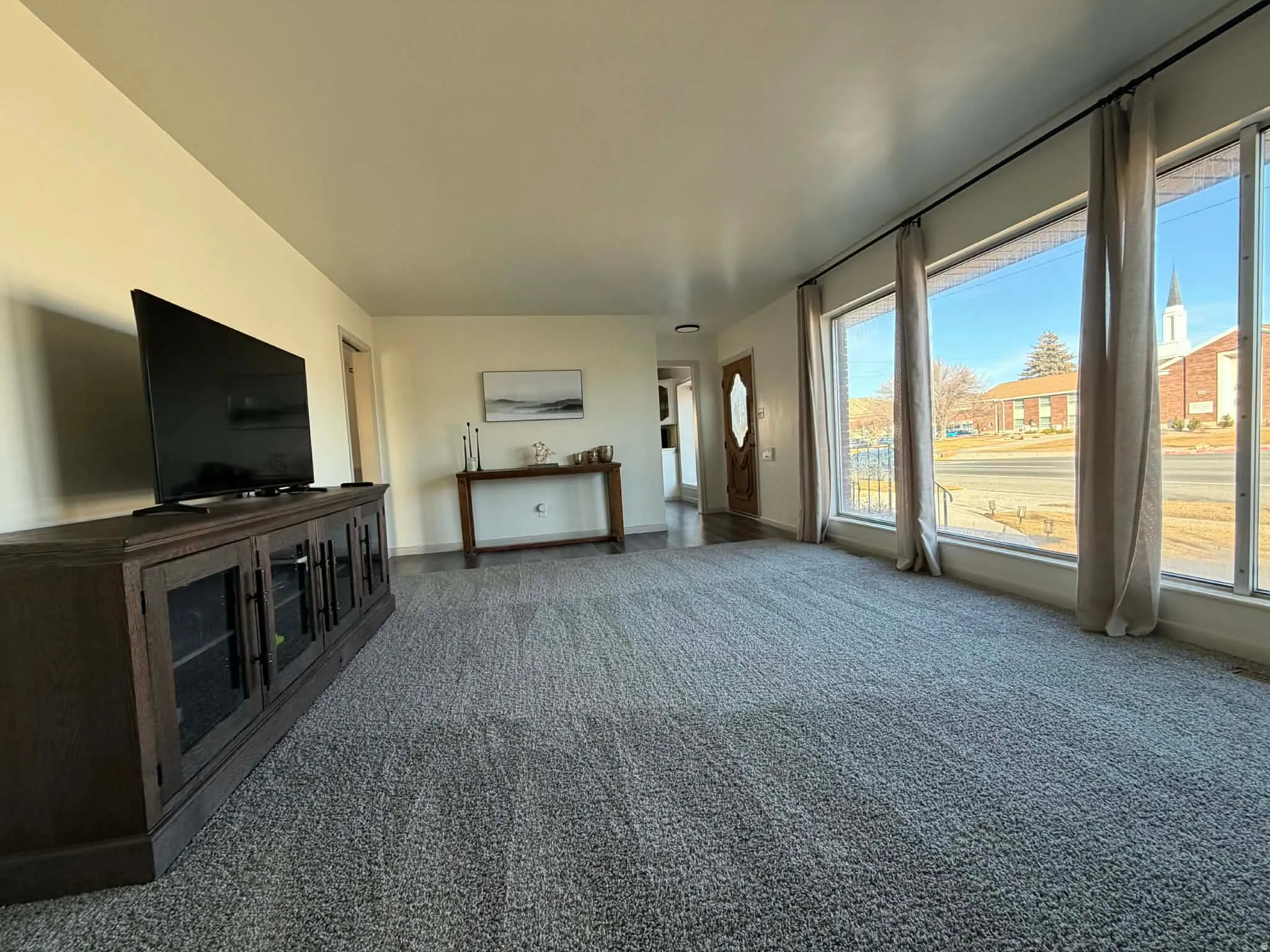 Unfurnished living room with carpet flooring and baseboards