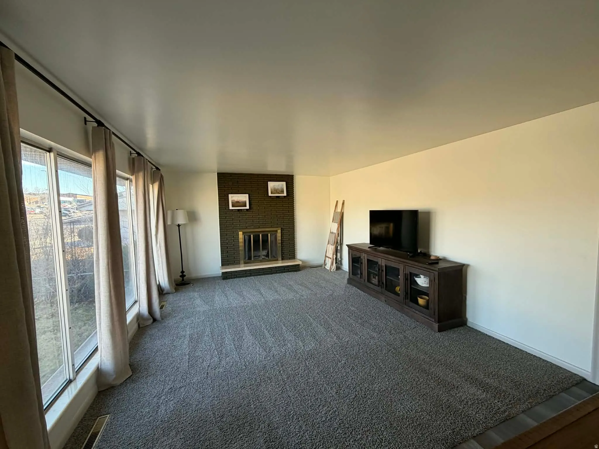 Unfurnished living room featuring a fireplace and dark colored carpet