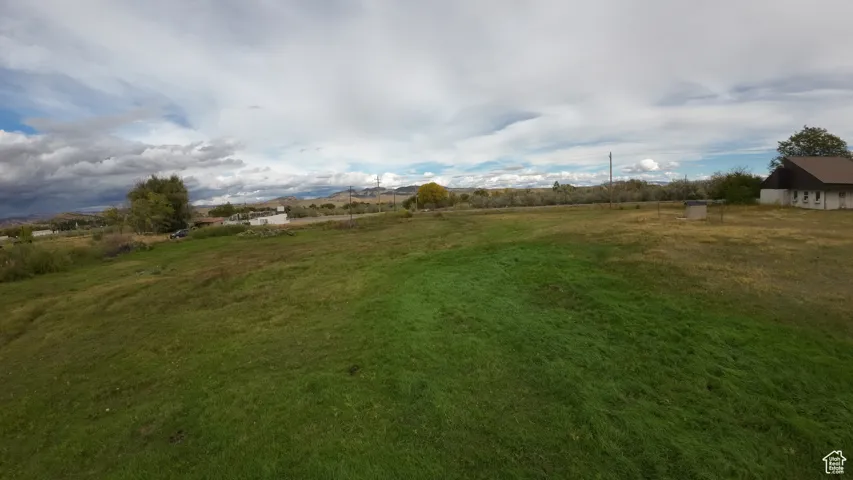 View of green lawn with a rural view