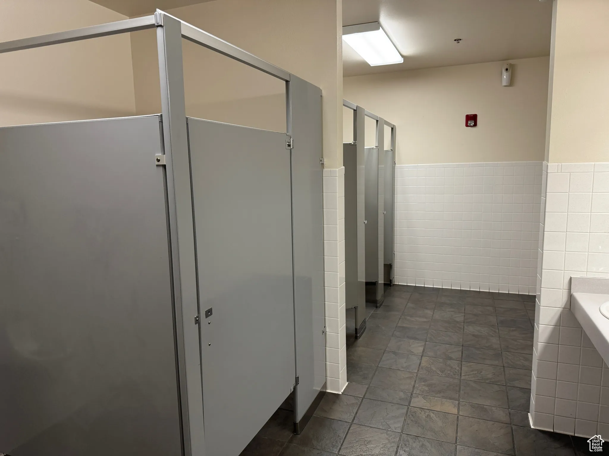 Bathroom featuring tile walls, a wainscoted wall, and a garden tub