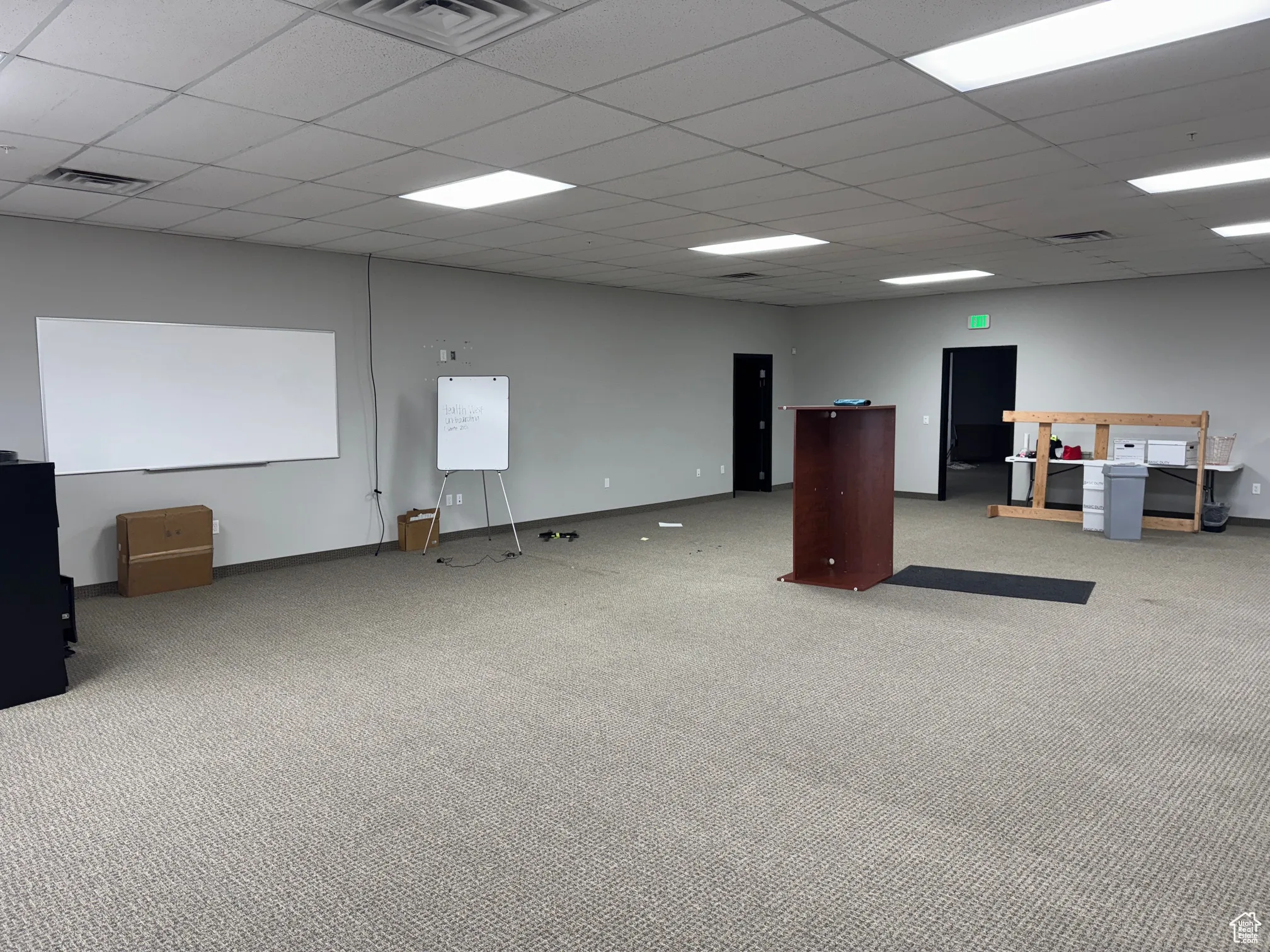 Carpeted spare room featuring a paneled ceiling