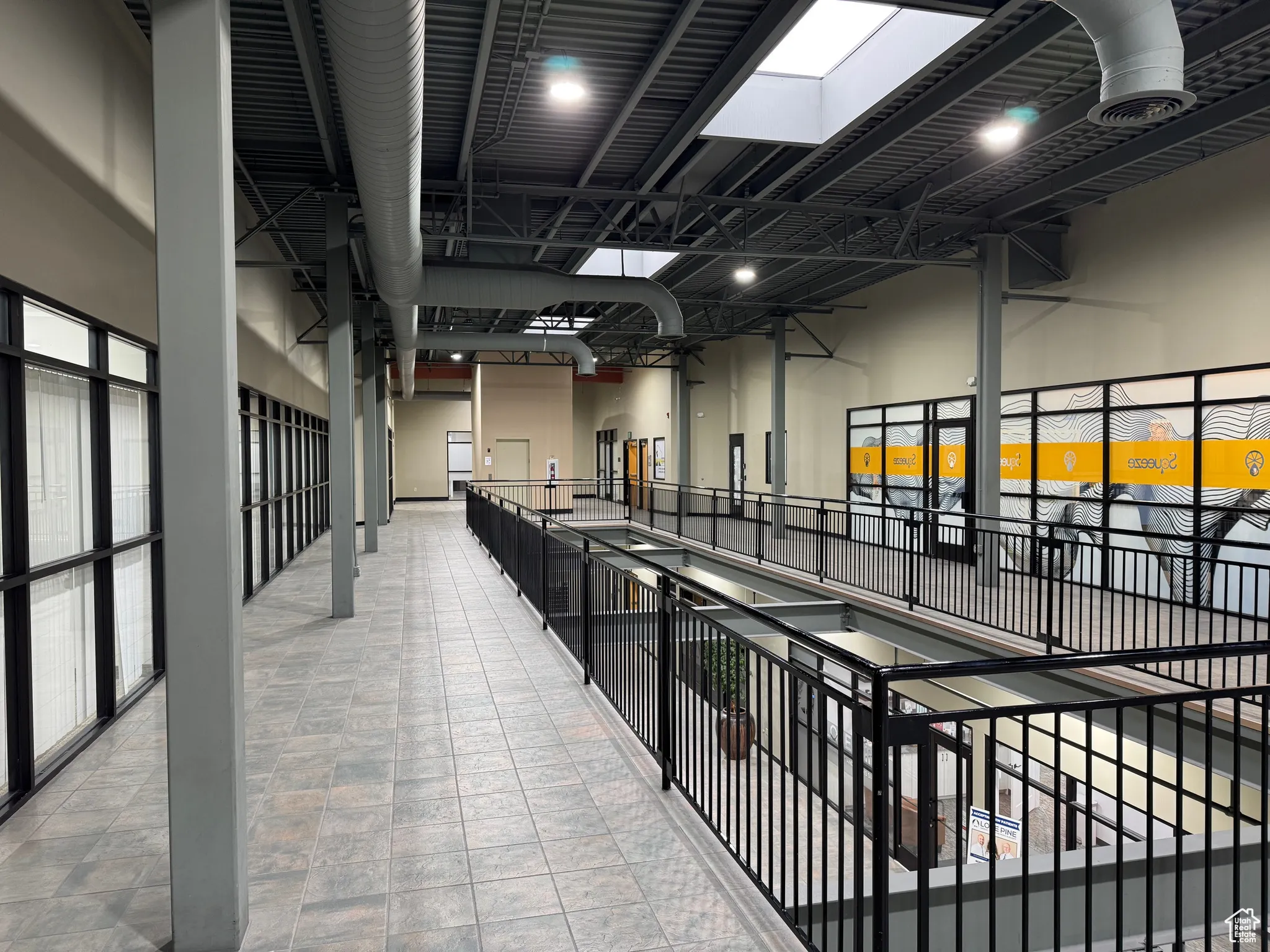 Hallway featuring a skylight and a towering ceiling
