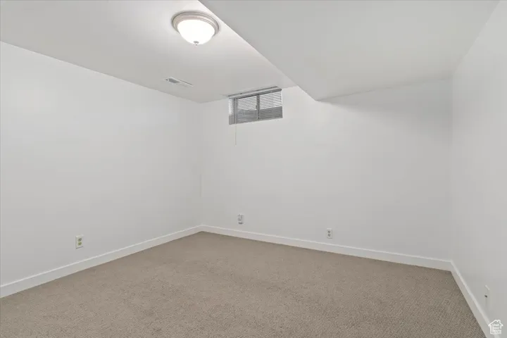 Carpeted spare room with baseboards