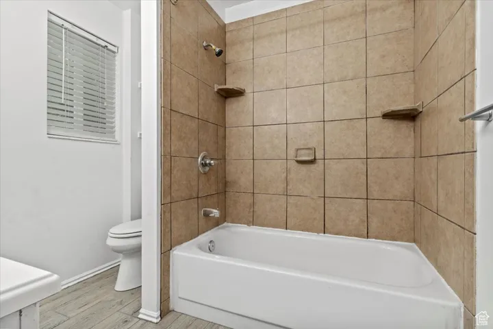 Full bathroom featuring shower / bath combination and wood finished floors