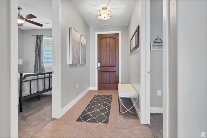 Entrance foyer featuring a ceiling fan and light carpet