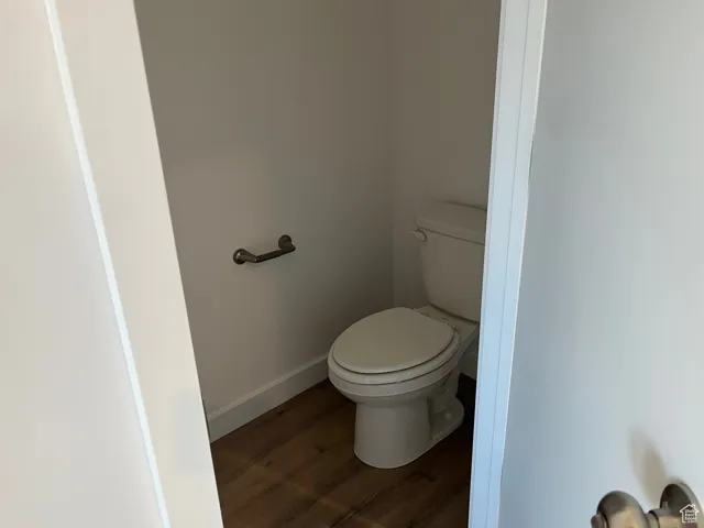 Bathroom featuring baseboards and dark wood-style flooring