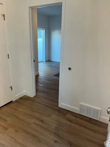 Hall with baseboards and dark wood-type flooring