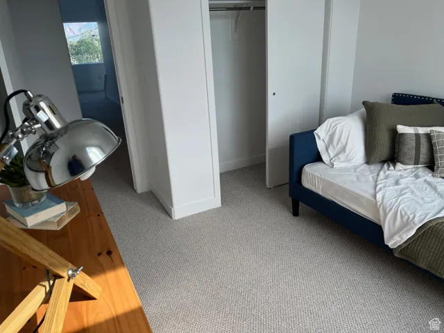 Bedroom with light carpet and a closet