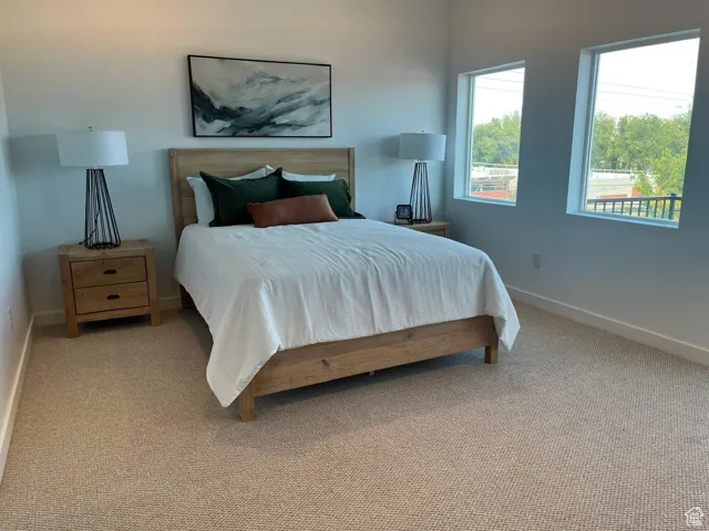 Bedroom featuring carpet and baseboards