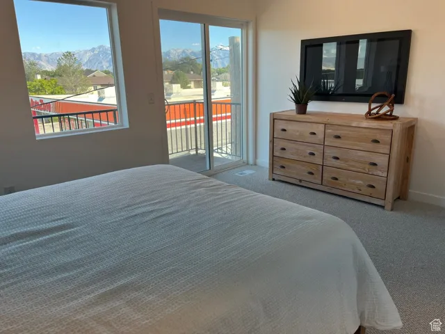 Carpeted bedroom featuring baseboards and access to exterior