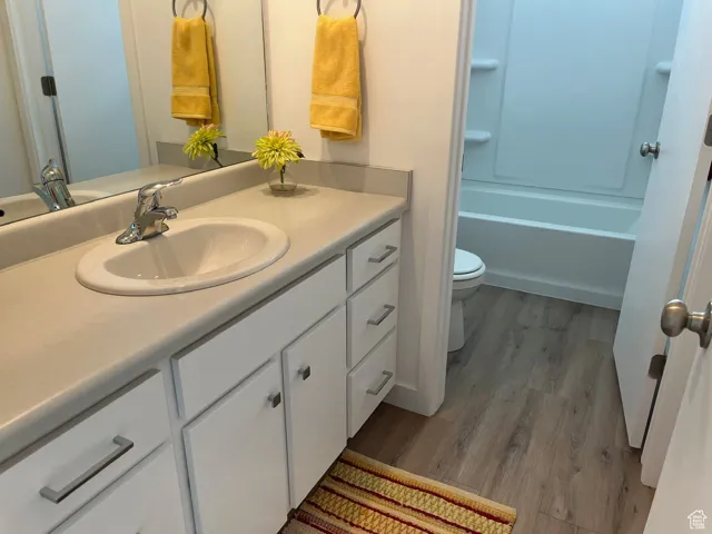 Bathroom with vanity, light wood-style floors, and bathtub / shower combination