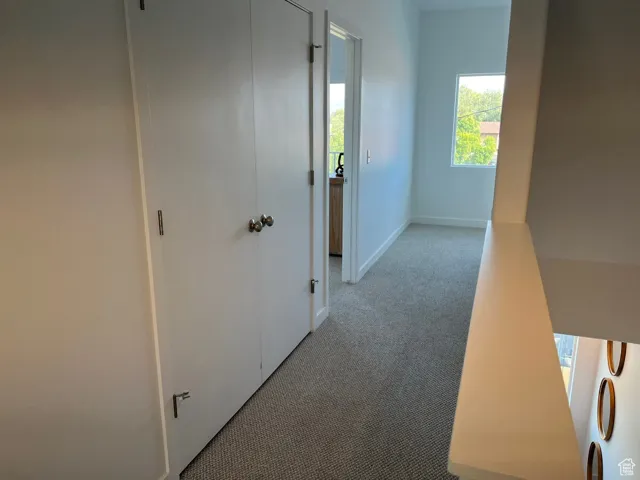 Hallway with carpet and baseboards