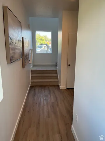 Corridor featuring stairway and dark wood-style flooring