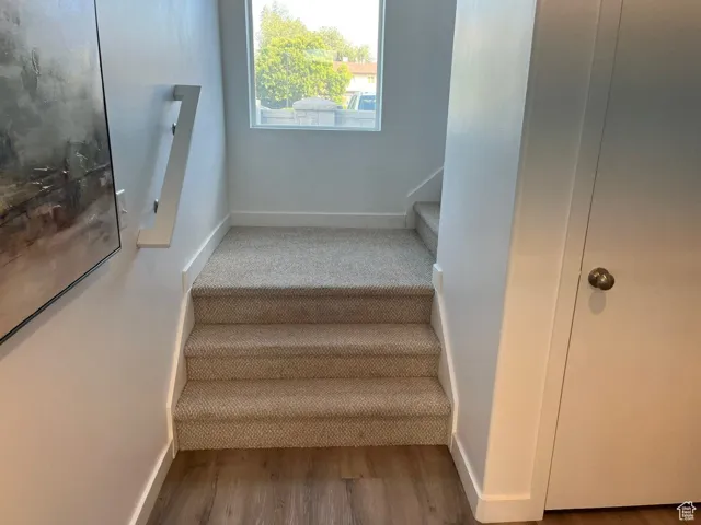 Stairway with baseboards and wood finished floors