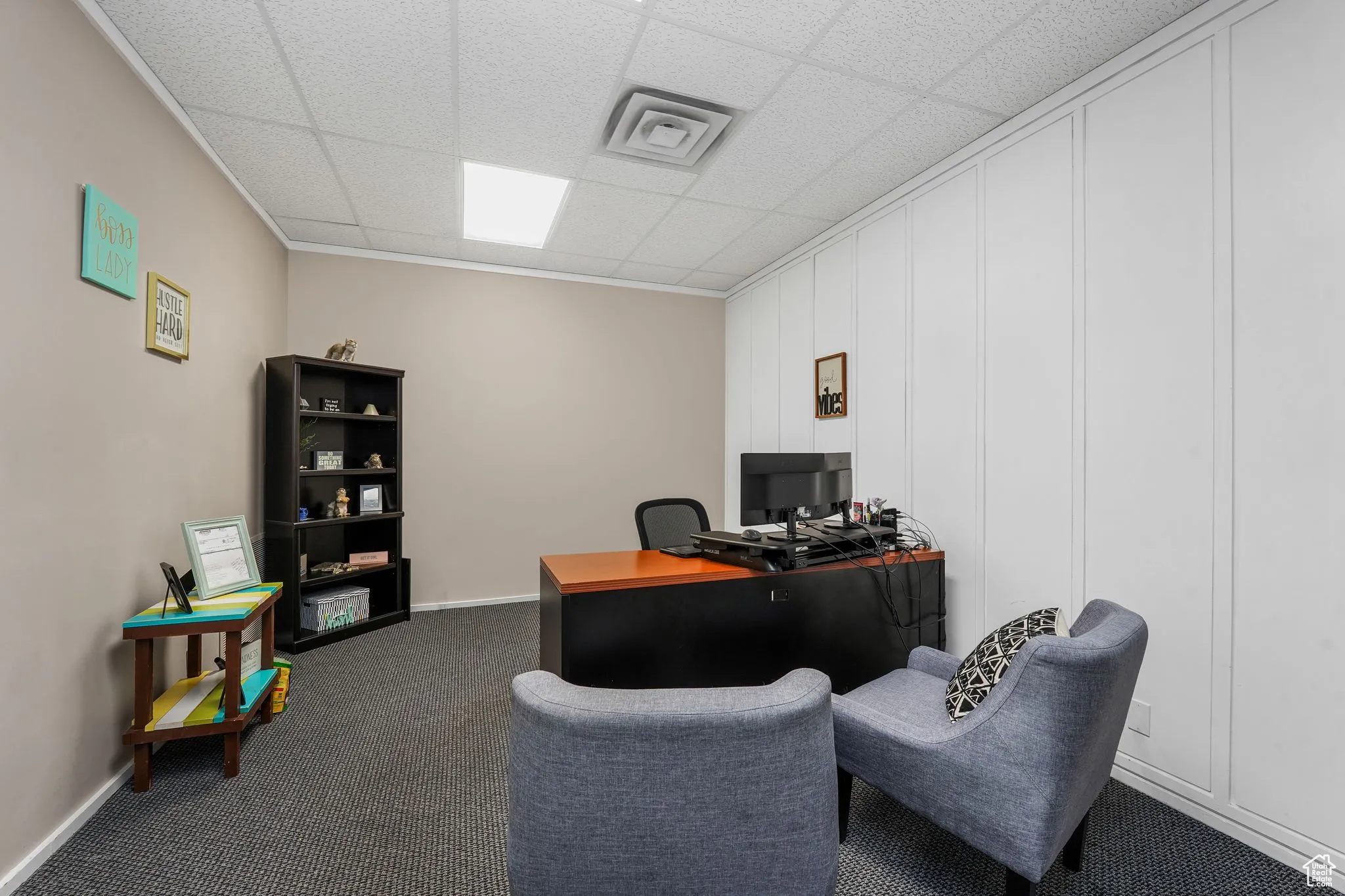 Home office featuring dark colored carpet and a drop ceiling