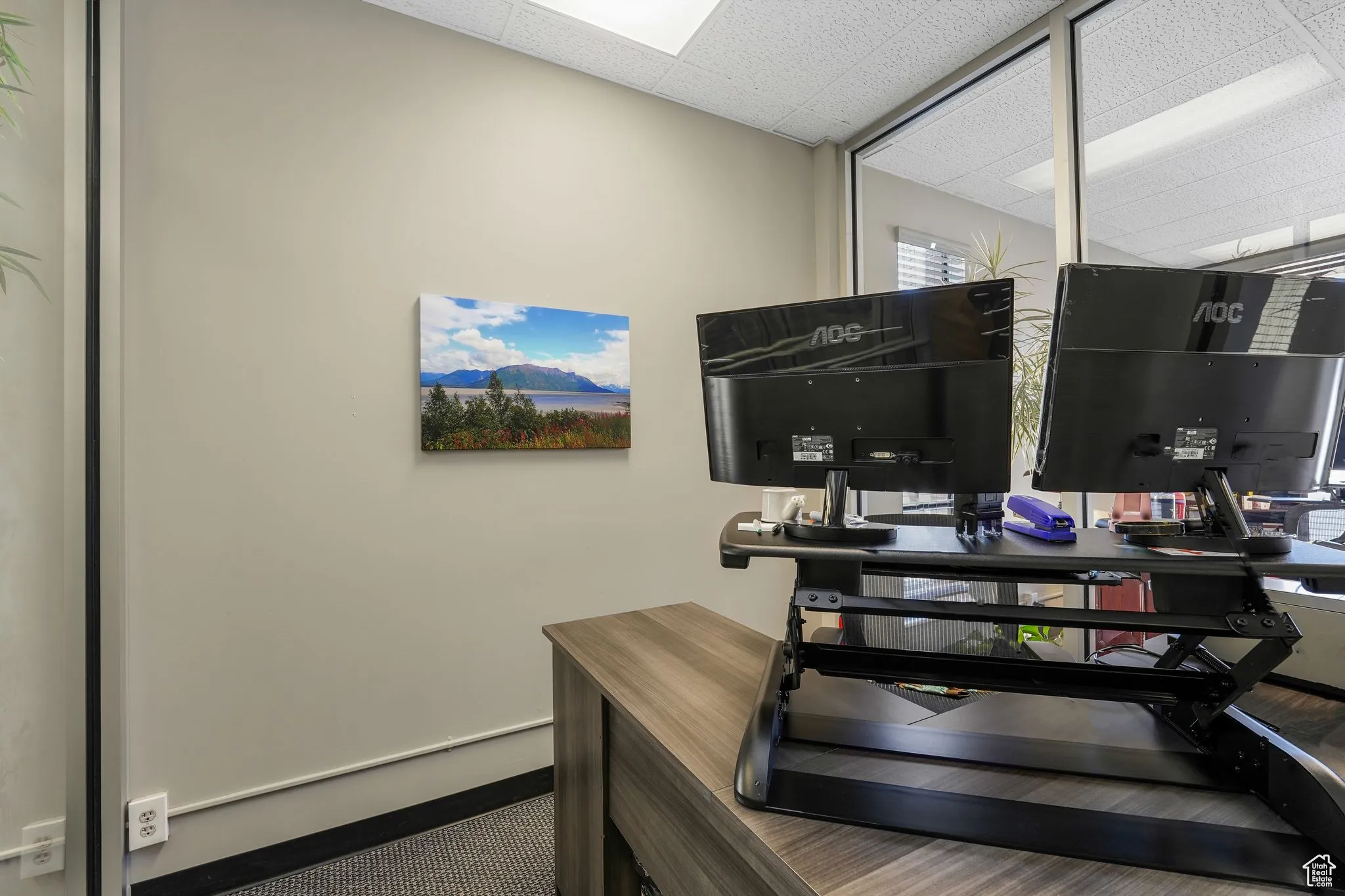 Office space with a paneled ceiling and baseboards