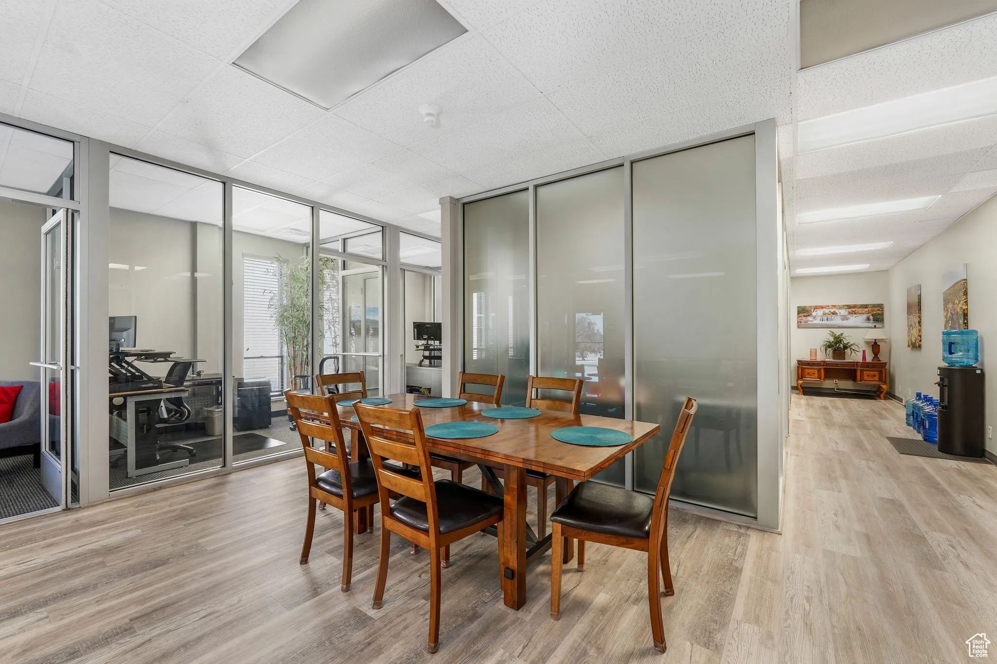 Dining room with light wood-type flooring and floor to ceiling windows