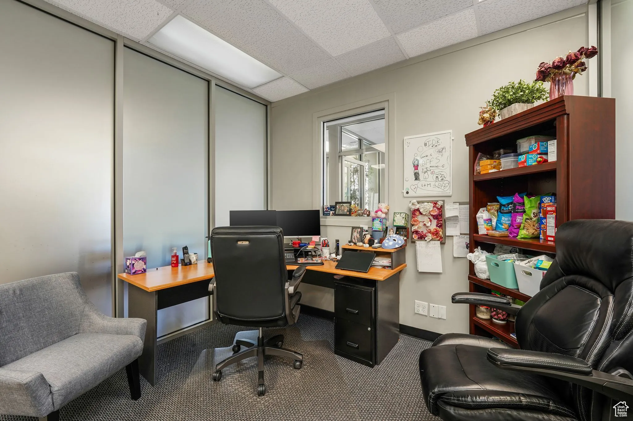 Home office featuring a drop ceiling and dark colored carpet