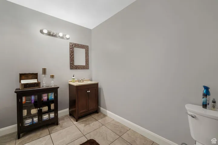 Half bath with vanity and light tile patterned floors