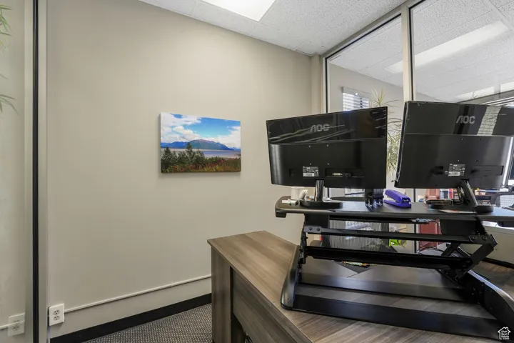Office space with a paneled ceiling and baseboards