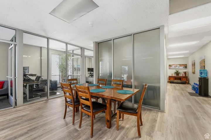 Dining room with light wood-type flooring and floor to ceiling windows