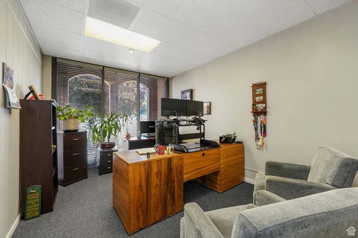Office area with dark colored carpet and expansive windows