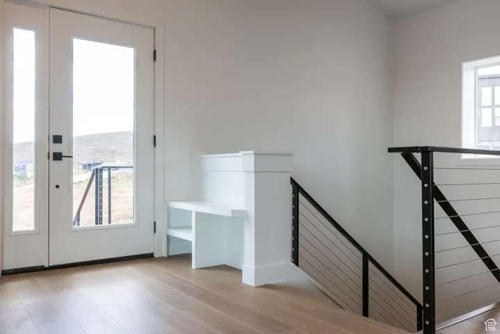 Stairway featuring wood finished floors, a water view, and french doors