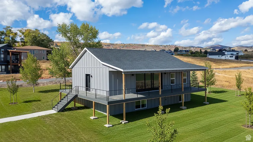 Rear view of house with covered walk-around deck. Landscape is virtual