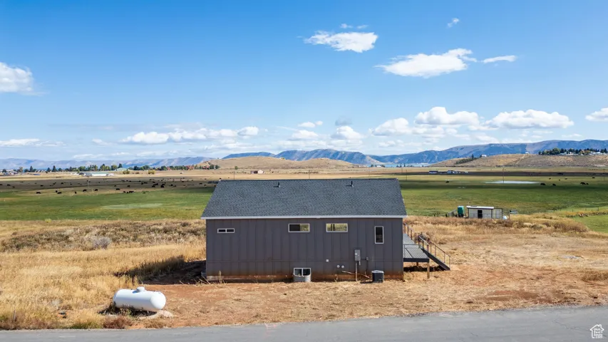 View of home's exterior featuring a mountain view, a rural view, and roof with shingles