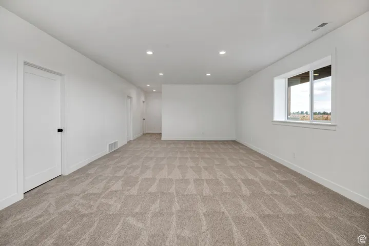 Spare room featuring recessed lighting and light colored carpet
