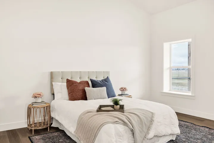 Bedroom featuring dark wood-style floors and baseboards