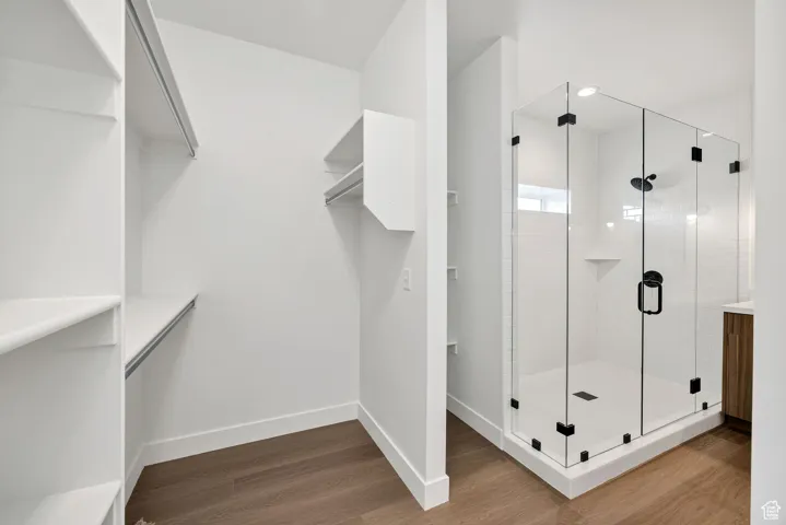 Bathroom featuring dark wood-style floors and a stall shower