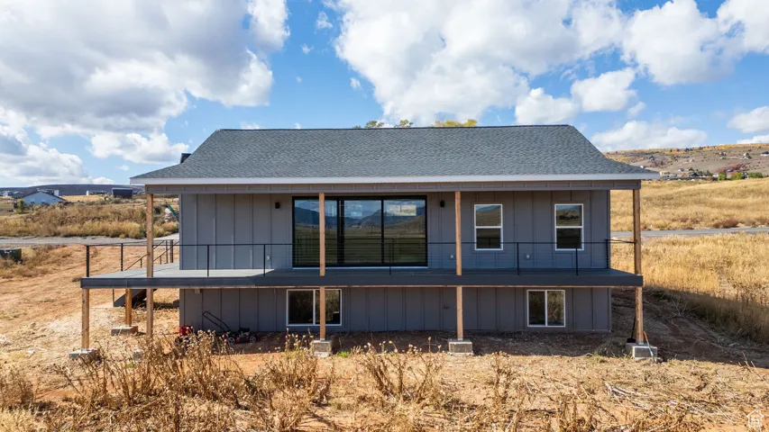 Rear view of property with roof with shingles and a deck