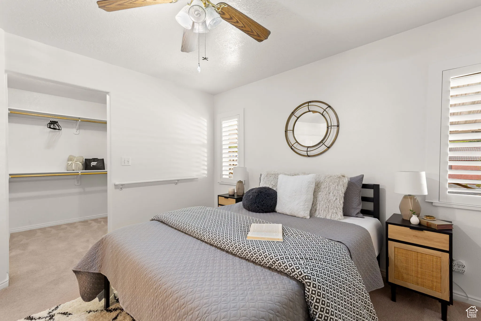 Bedroom with carpet, a spacious closet, and ceiling fan