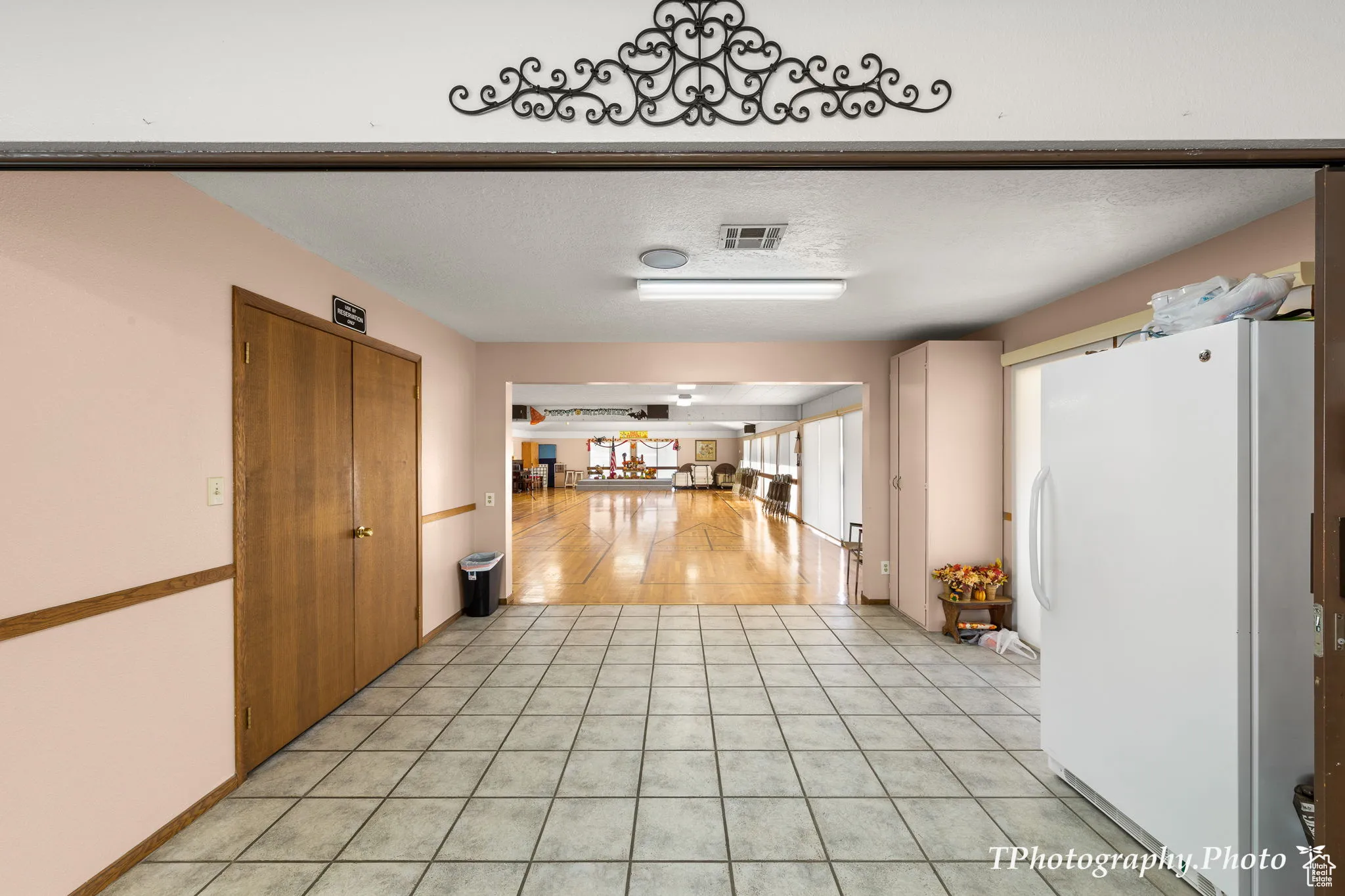 Hallway featuring light tile patterned floors and a textured ceiling
