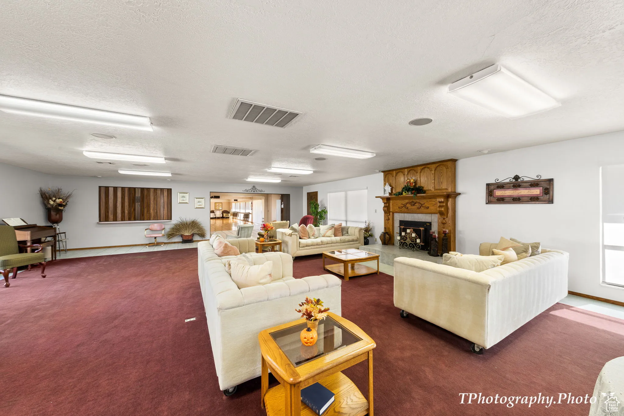 Living room with a textured ceiling, a fireplace, healthy amount of natural light, and dark colored carpet
