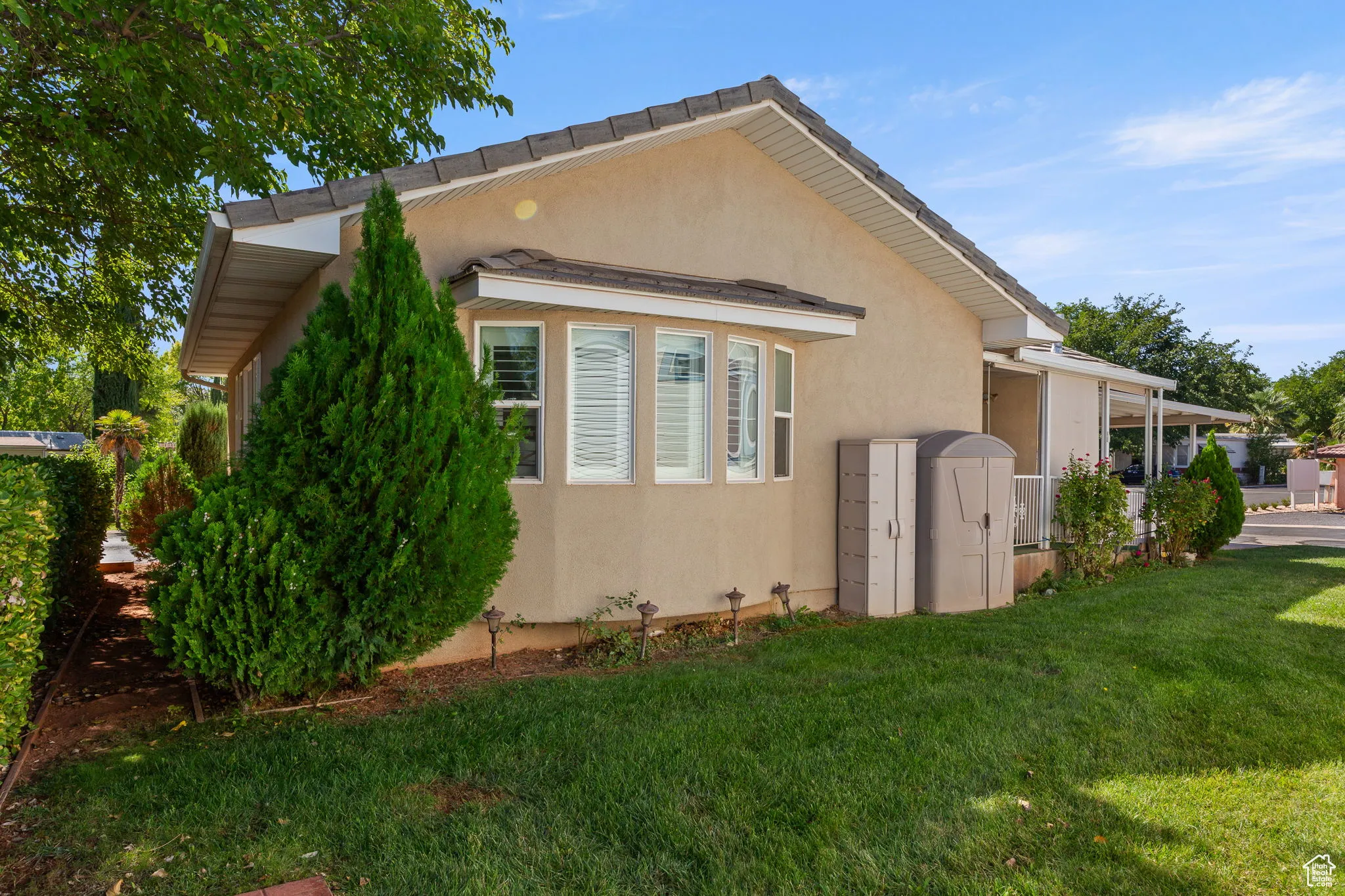 View of side of home with a yard and stucco siding
