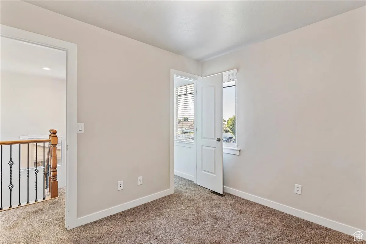 Unfurnished bedroom with baseboards and carpet