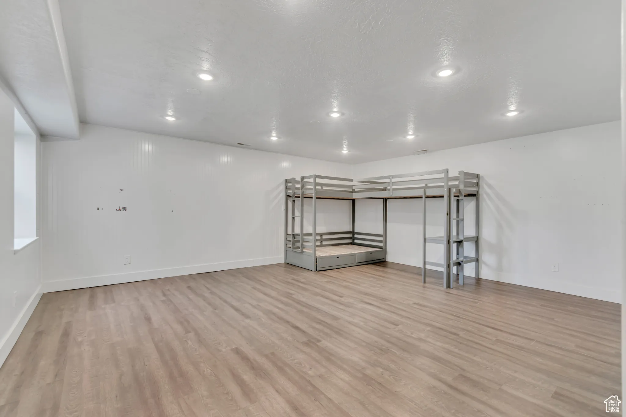 Additional living space featuring light wood-style flooring and recessed lighting