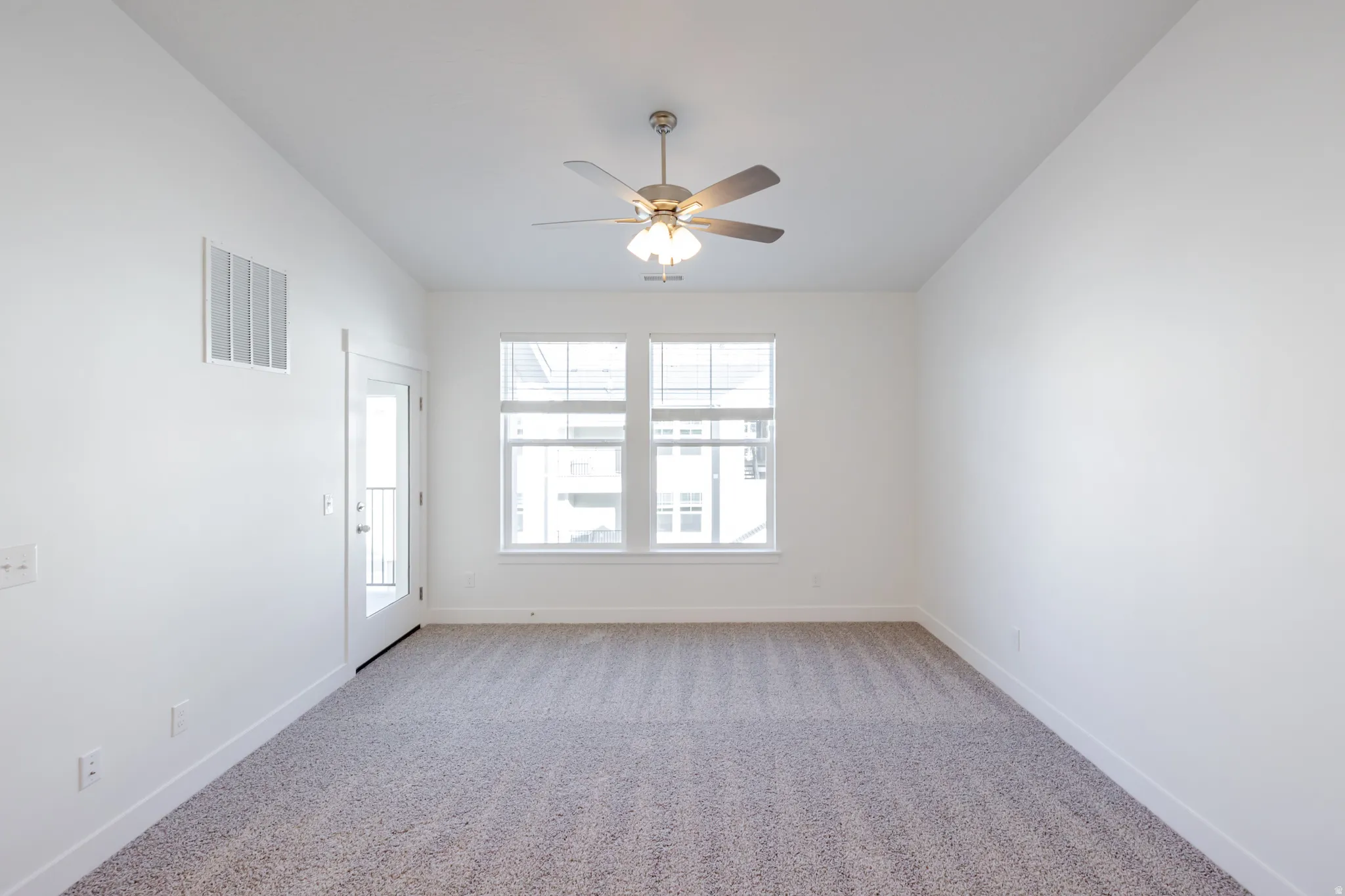 Spare room with light colored carpet and a ceiling fan
