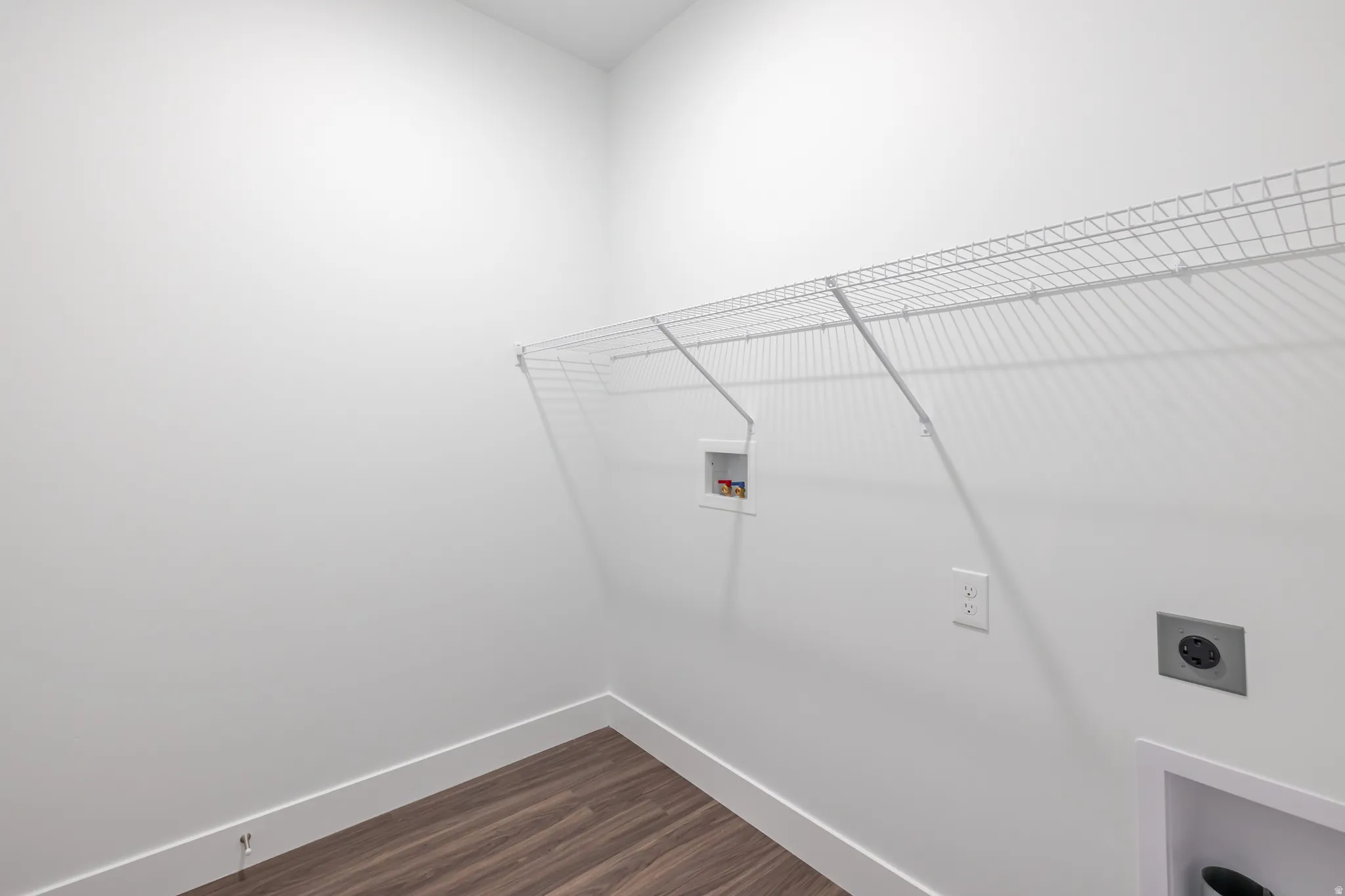 Laundry area with dark wood-style flooring, washer hookup, and electric dryer hookup