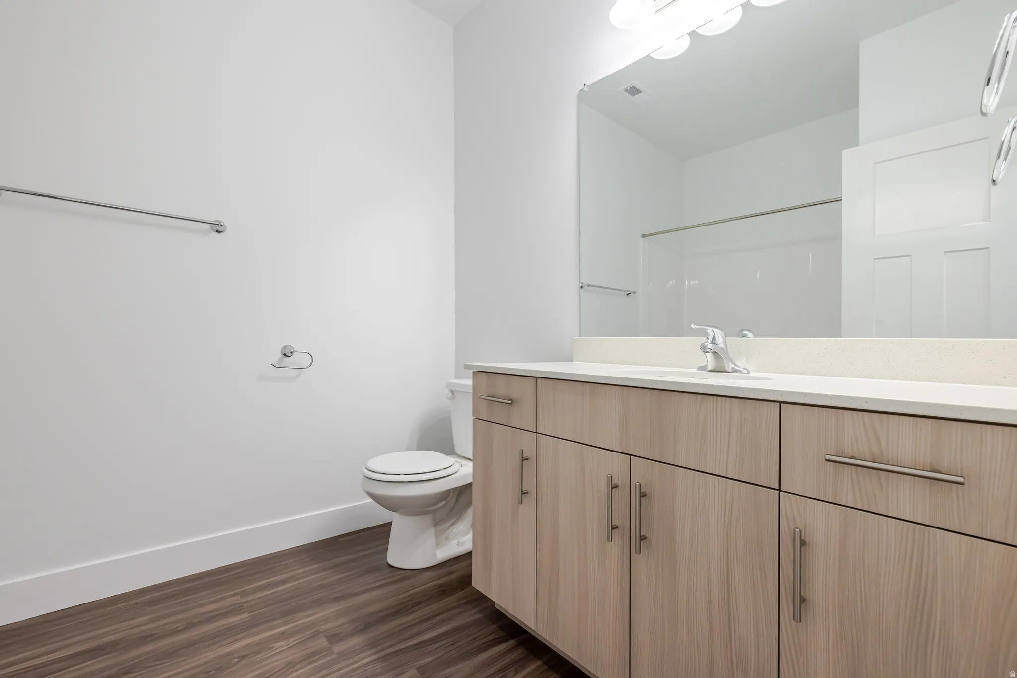 Bathroom with vanity, dark wood-type flooring, and a shower
