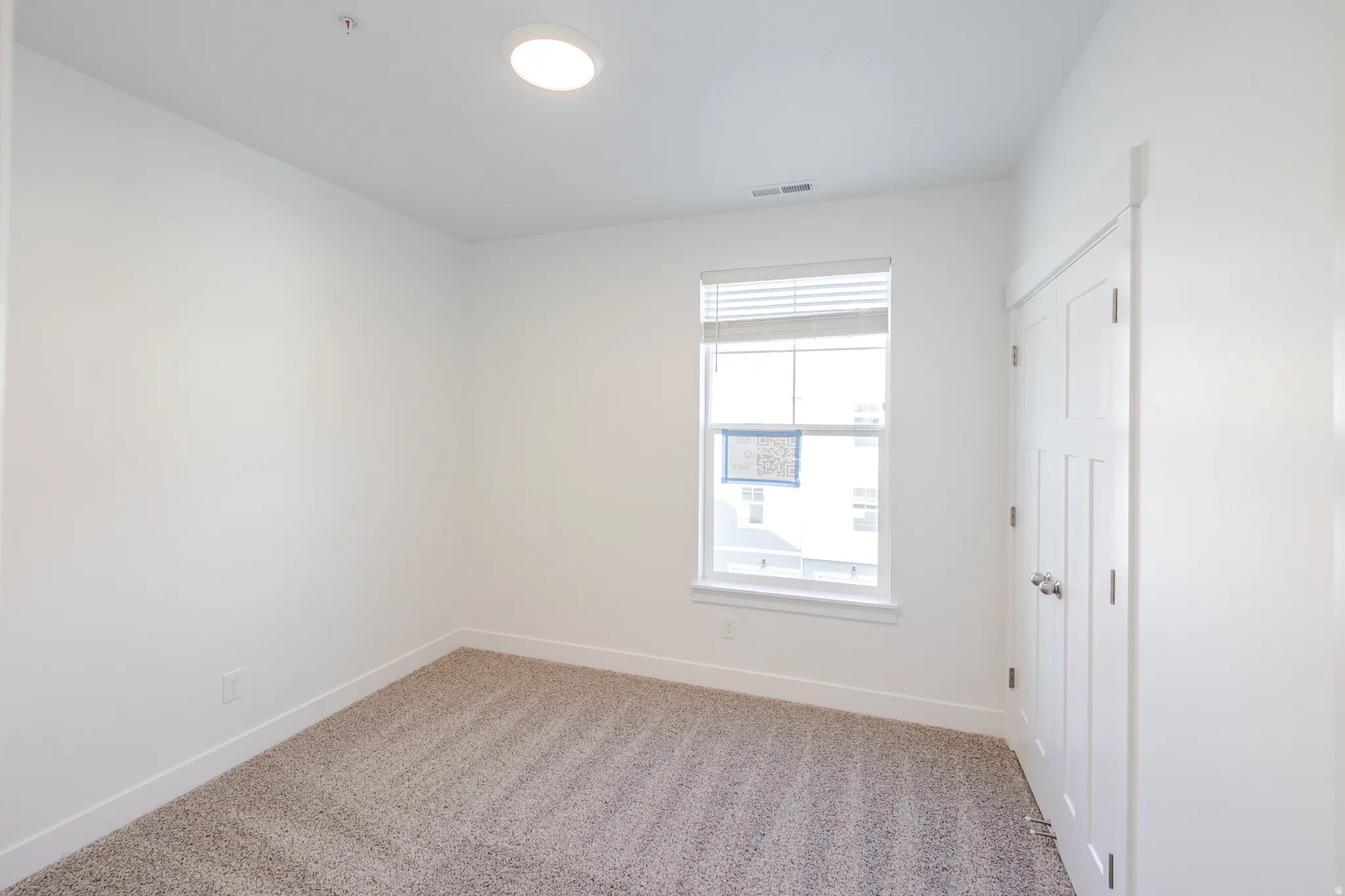 Unfurnished room with baseboards and light carpet