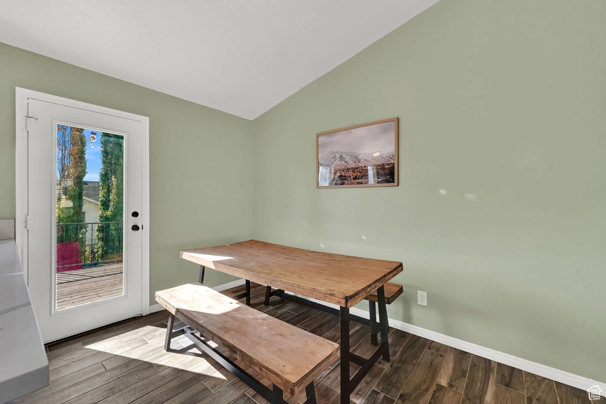 Dining space with vaulted ceiling and wood finished floors