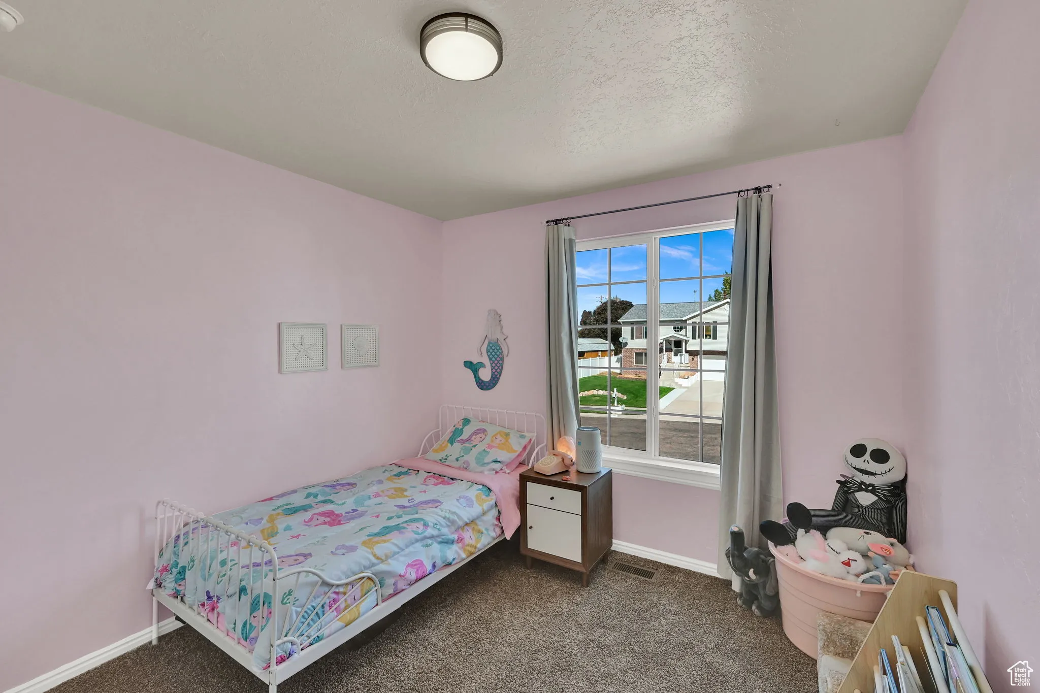 Bedroom featuring dark colored carpet and a textured ceiling