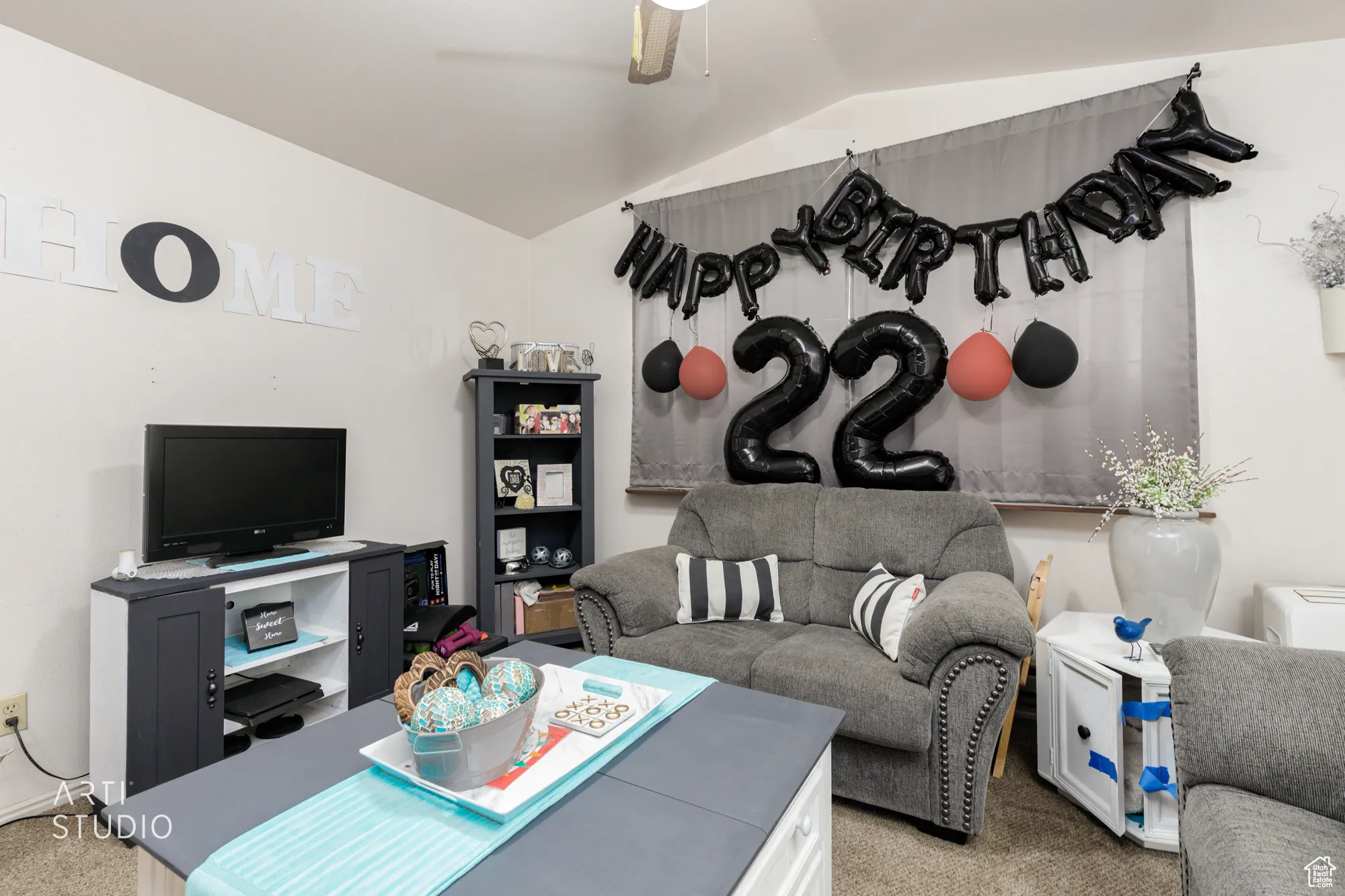Carpeted living area with lofted ceiling and a ceiling fan