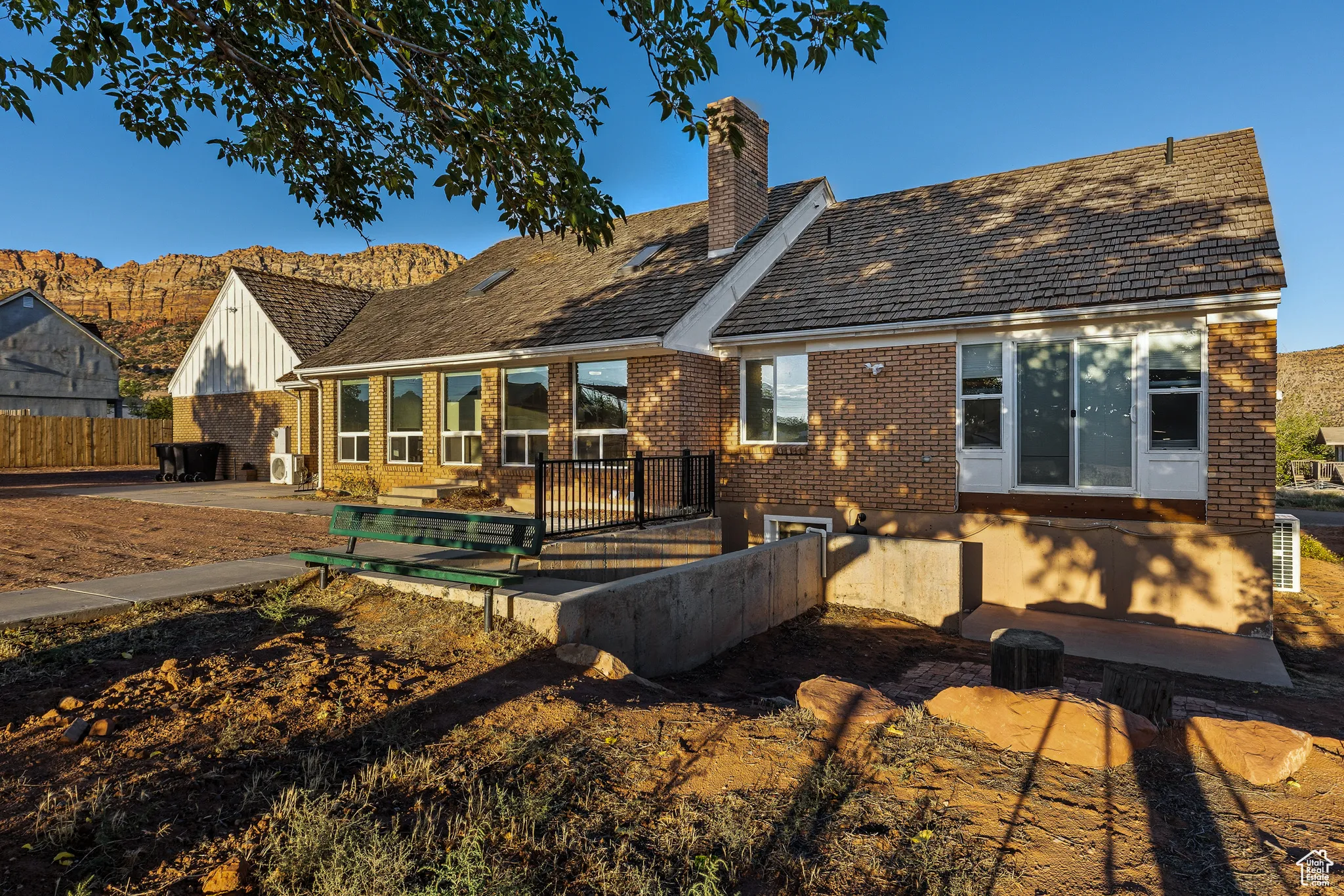 Back of property with brick siding, a patio area, and a chimney